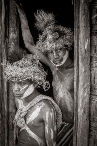 Two men in costume are standing next to a wooden wall.