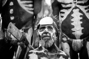 A man with painted face and body art.