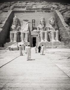 A group of people standing in front of an egyptian temple.