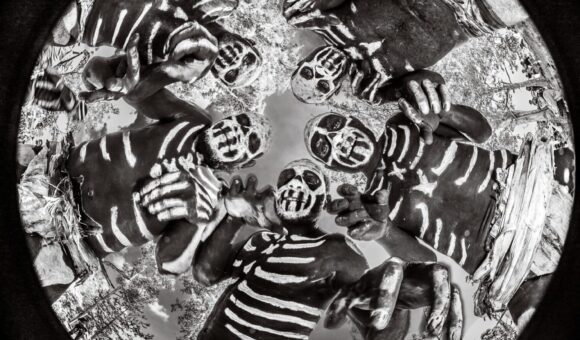 A black and white photo of zebras in the middle.