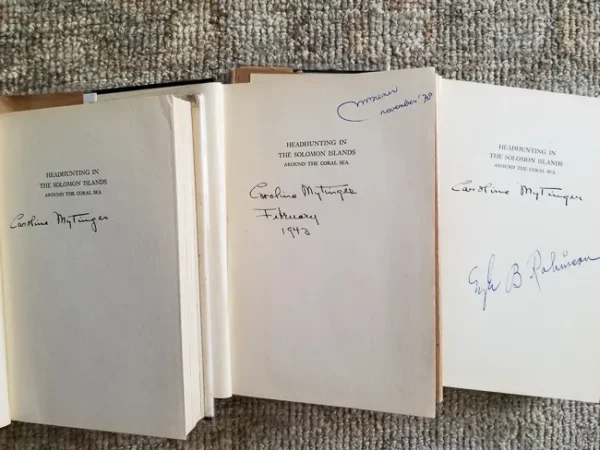 Three open books with handwritten notes.